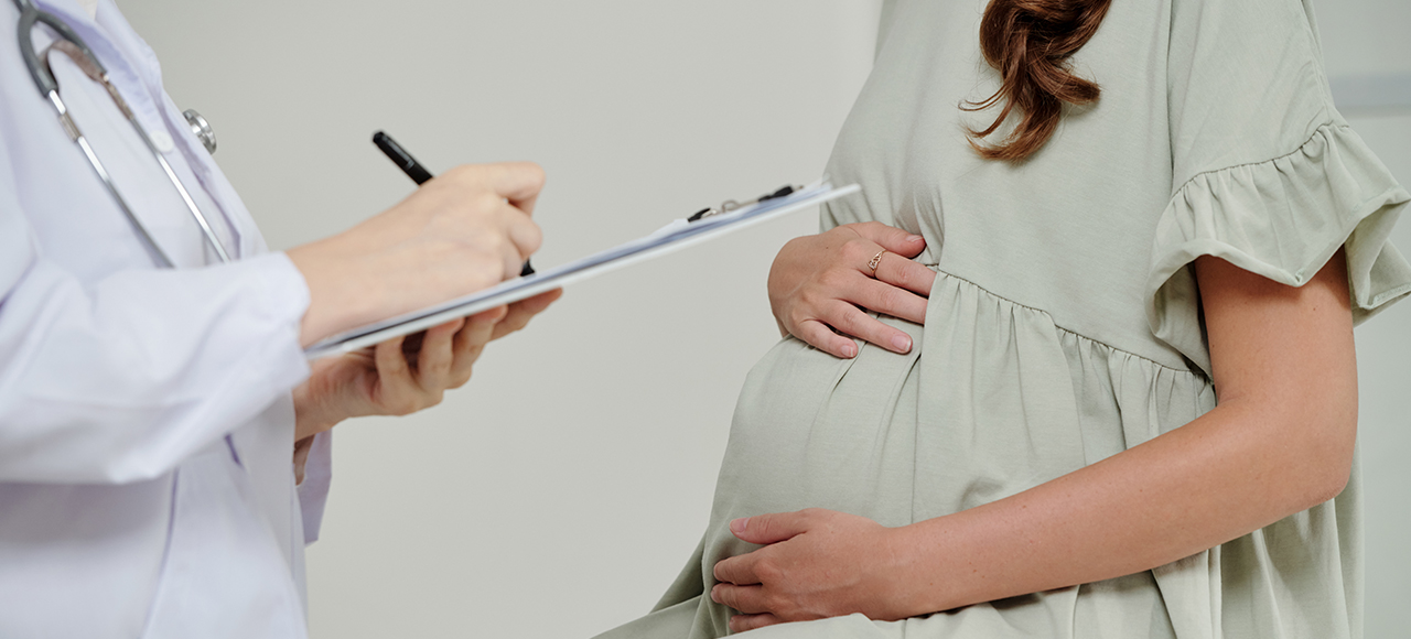 Mulher com mão na barriga, dosagem de sangue