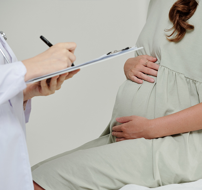 Mulher com mão na barriga, dosagem de sangue